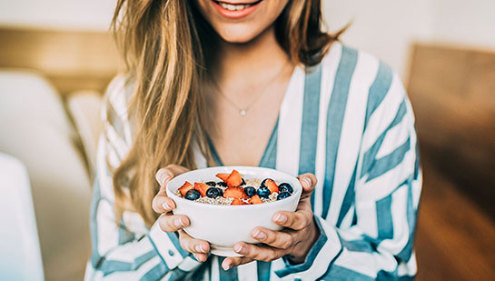 Woman eating a healthy cereal after receiving diet guidance from Laurel chiropractor