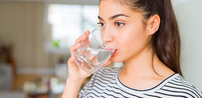 Woman drinking water to be healthy under the guidance of Laurel chiropractor